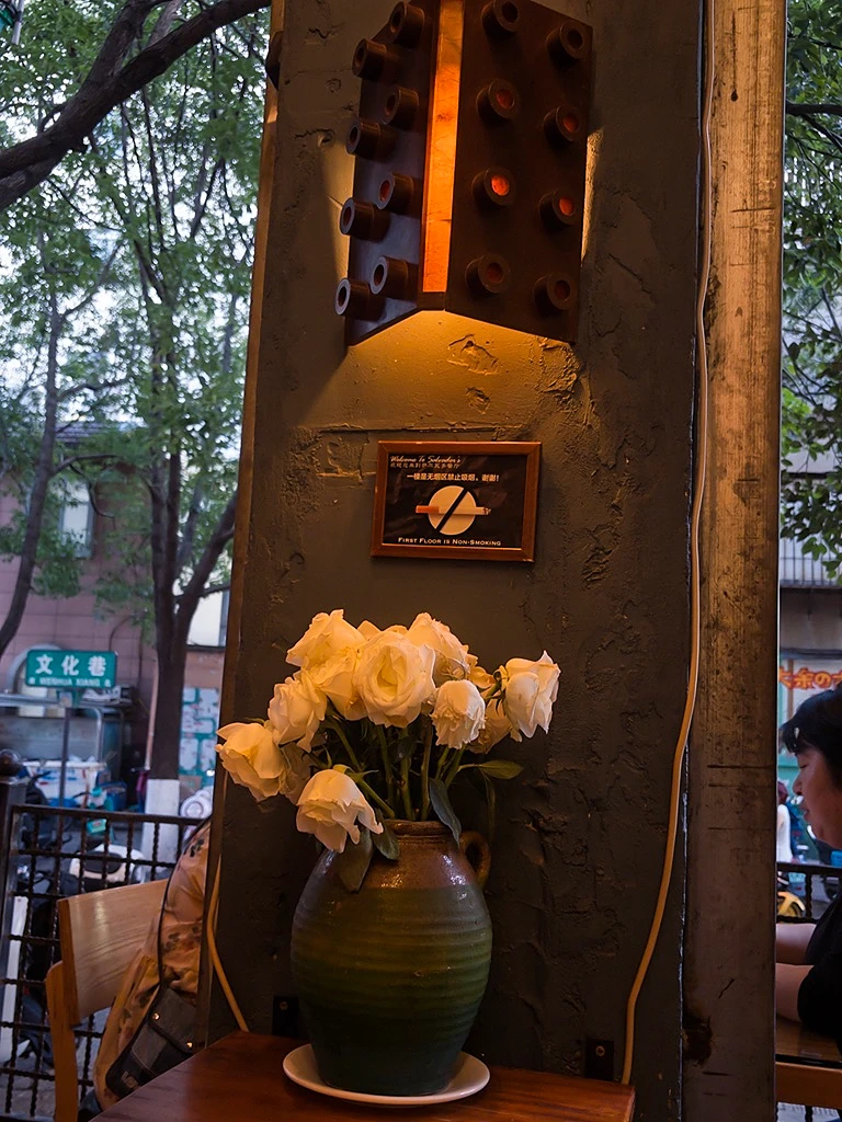 暮色跌入街角，温热的光在白玫瑰里安眠
